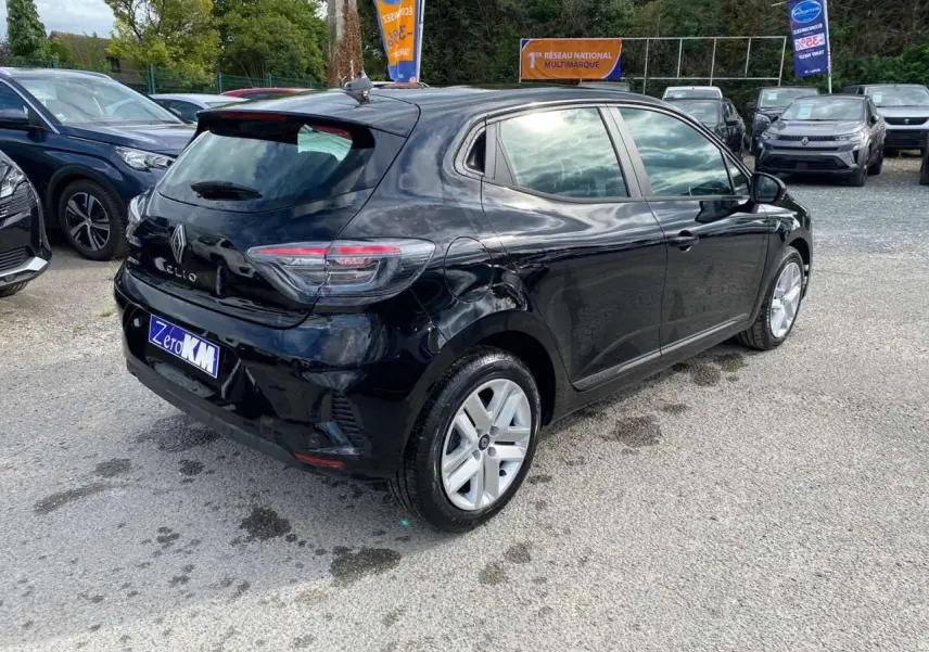 Vue 3/4 arrière droite d'une Renault Clio noire étoile 2025 avec feux LED et jantes alliage visibles.