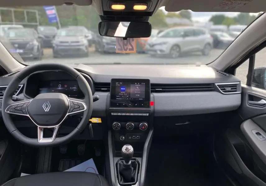 Intérieur de la Renault Clio 2025 noir étoilé, vue de face sur le tableau de bord avec écran tactile et boîte manuelle.
