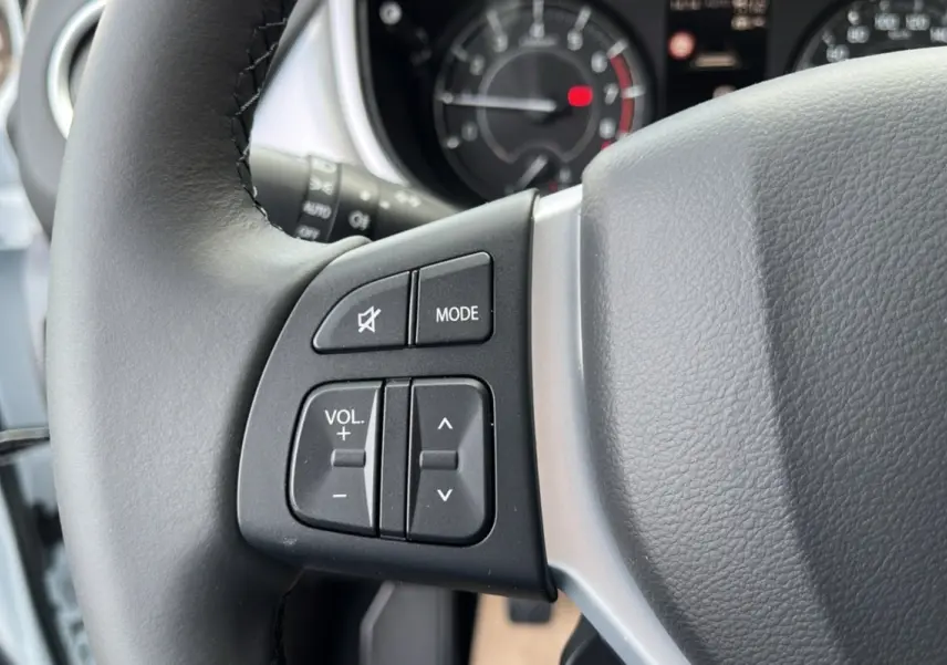 Gros plan sur les commandes audio au volant du Suzuki Vitara 2025 White Pearl, version hybride essence automatique.
