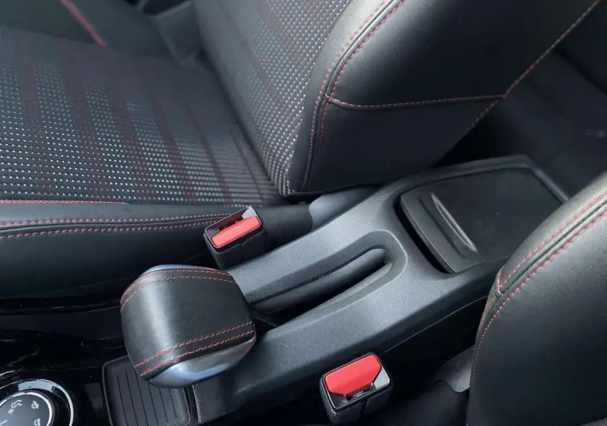 Gros plan sur la console centrale et les sièges noirs avec surpiqûres rouges du Peugeot 2008 GT Line blanc de 2016.