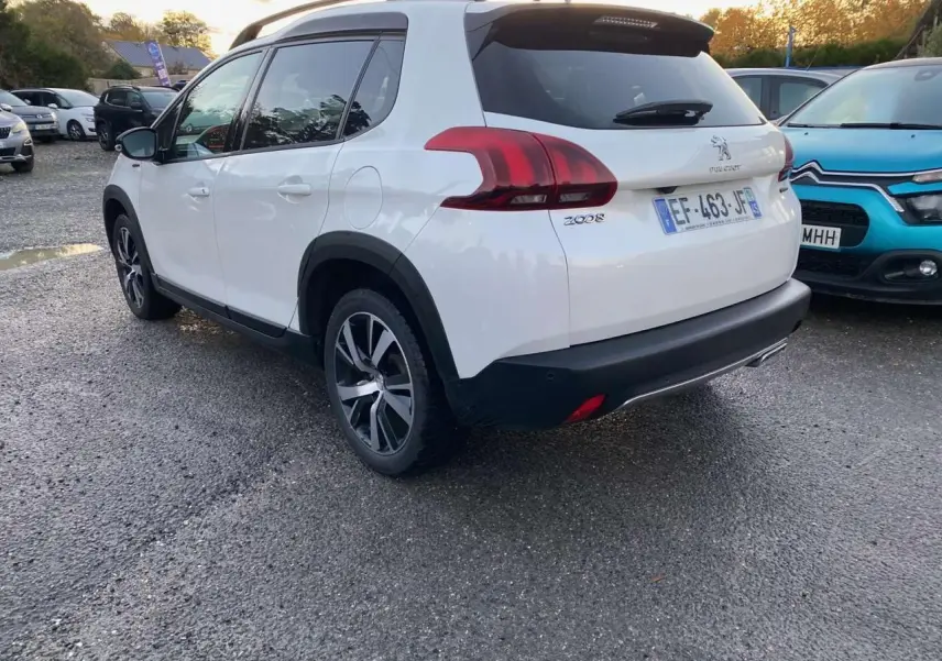 Peugeot 2008 blanc en 3/4 arrière droit, avec jantes alliage et détails noirs contrastants visibles.