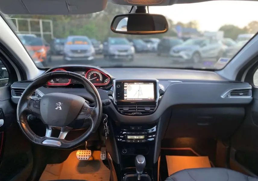 Intérieur du Peugeot 2008 GT Line 2016 vu de face, avec tableau de bord noir et écran tactile central allumé.