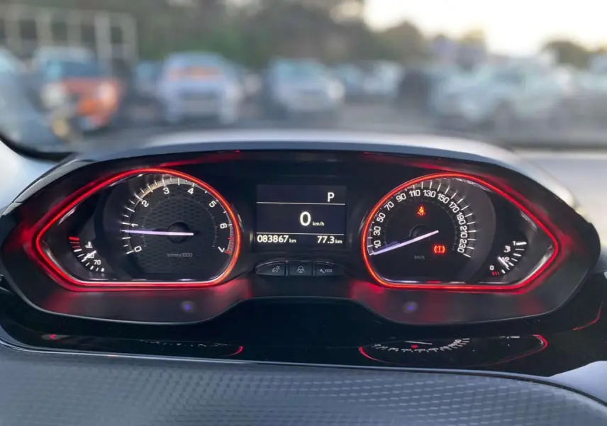 Tableau de bord du Peugeot 2008 GT Line 2016, affichage numérique avec compte-tours et vitesse entourés de lumière rouge.