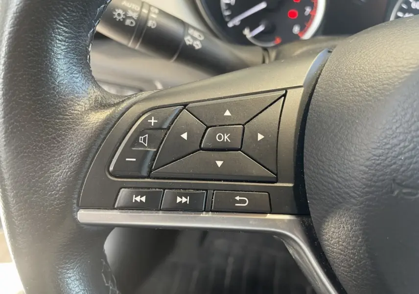 Gros plan sur les commandes multifonctions du volant en cuir noir d'une Nissan Micra IG-T 100 N-Connecta 2020.