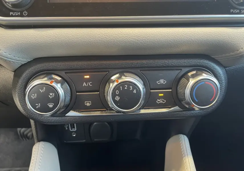Commandes de climatisation manuelle en gros plan dans l'habitacle beige d'une Nissan Micra IG-T 100 N-Connecta 2020.