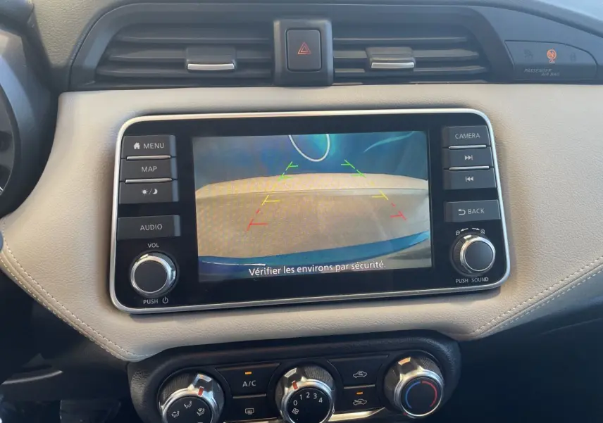 Vue rapprochée de l'écran tactile du tableau de bord beige de la Nissan Micra bleu, affichant la caméra de recul.