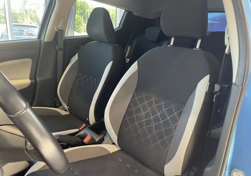 Vue intérieure côté conducteur de la Nissan Micra IG-T 100 N-Connecta bleue, sièges avant noirs avec surpiqûres grises.