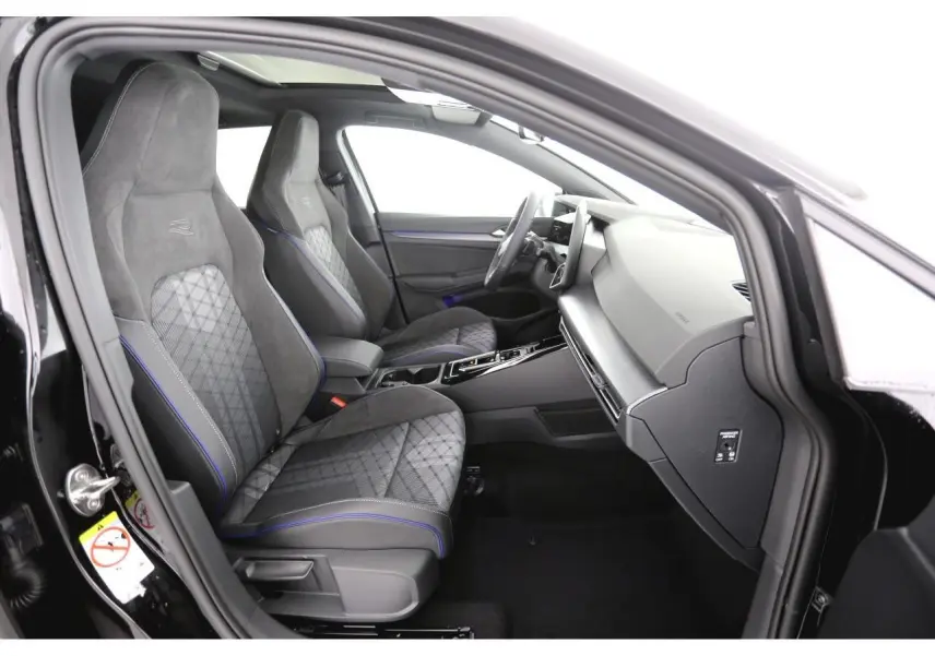 Vue intérieure côté passager avant de la Volkswagen Golf VIII R-Line avec sièges sport gris à surpiqûres bleues et toit ouvrant panoramique.