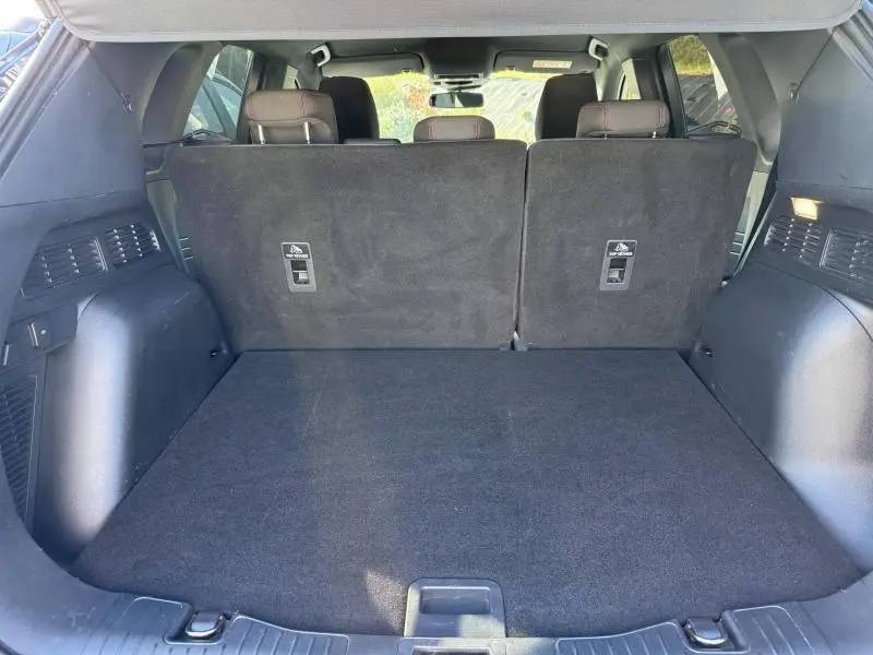 Vue depuis l'arrière du coffre noir spacieux du Ford Kuga 2.0 EcoBlue 120ch ST-Line avec banquette arrière relevée.