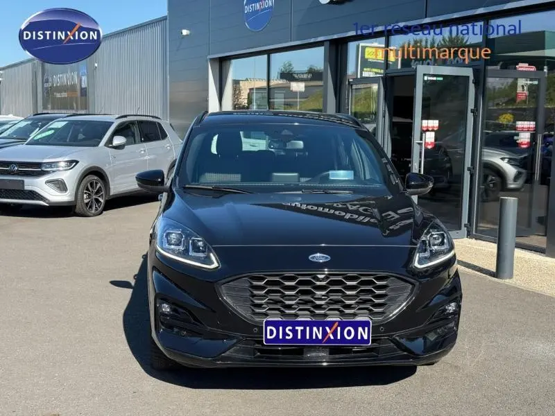 Vue avant d'un Ford Kuga 2.0 EcoBlue 120ch ST-Line noir Agate métallisé, avec calandre hexagonale et phares LED.