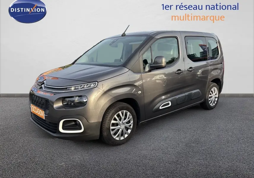 Vue 3/4 avant droit d'un Citroën Berlingo Multispace gris platinium avec protections latérales blanches et jantes alliage.