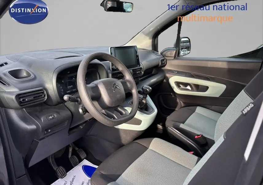 Vue intérieure côté conducteur du Citroën Berlingo Multispace gris platinium, avec tableau de bord et sièges bicolores.