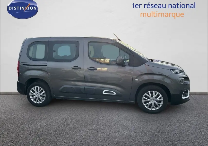 Vue de profil côté gauche d'un Citroën Berlingo Multispace gris platinium avec jantes alliage et protections latérales blanches.
