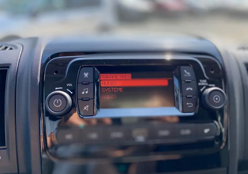Détail de la console centrale du Citroën Jumper 2023 avec écran audio affichant les paramètres en rouge.