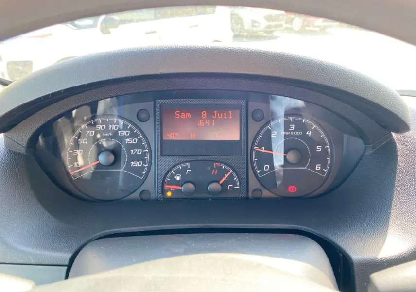 Vue rapprochée du tableau de bord du Citroën Jumper 2023 avec compteurs analogiques et écran digital rouge.