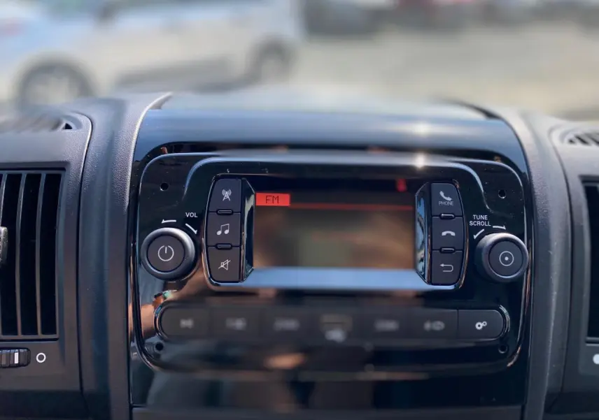 Tableau de bord du Citroën Jumper 2023 montrant l'autoradio avec écran et commandes en façade noire brillante.