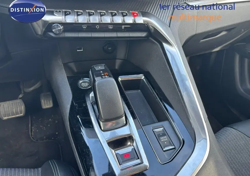 Gros plan sur la console centrale du Peugeot 3008 gris platinium 2022, mettant en valeur le levier de vitesse automatique et les commandes.