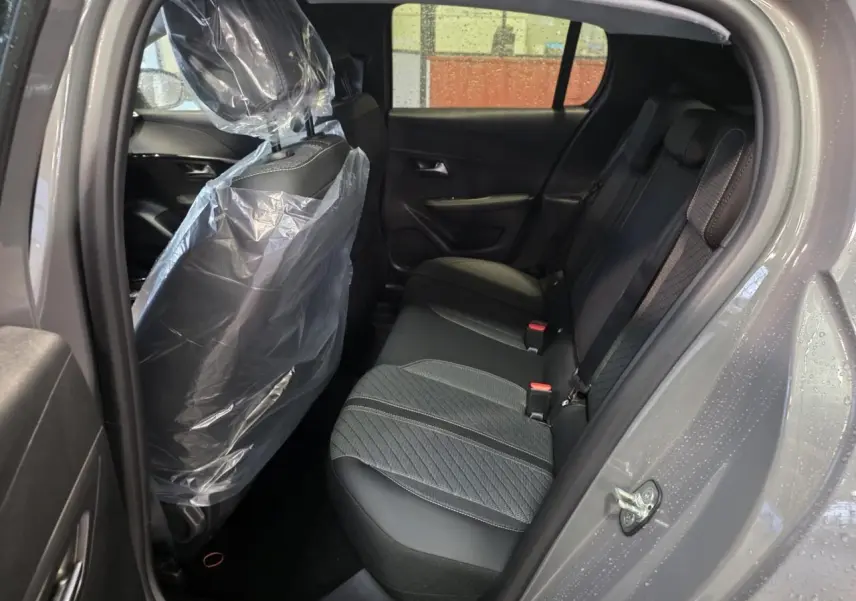 Vue intérieure côté droit de la banquette arrière tissu noir et gris d'une Peugeot 208 Gris Selenium 2025.