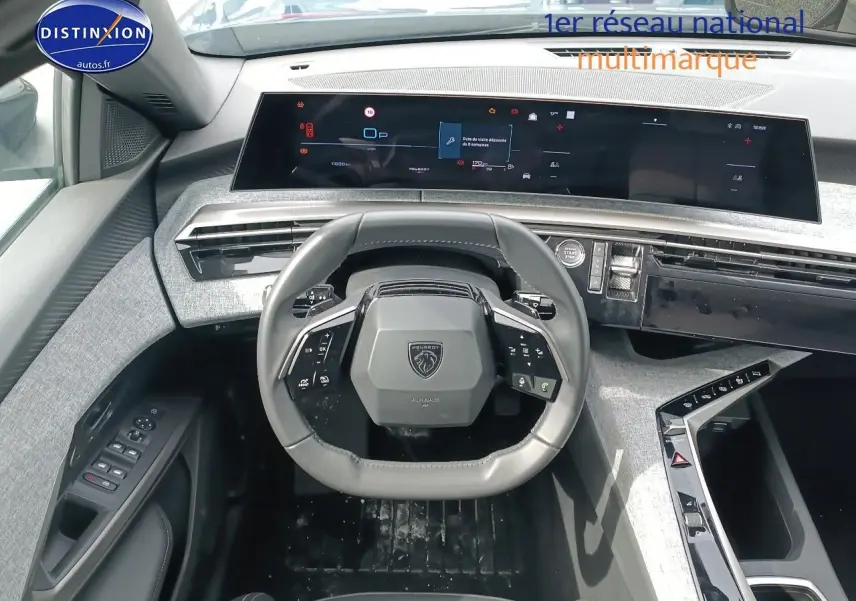 Vue intérieure frontale du tableau de bord et volant cuir noir du Peugeot 5008 Hybrid 145 allure 2025 avec écran tactile panoramique.