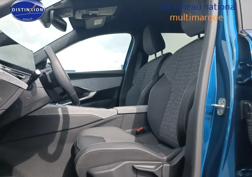 Intérieur avant du Peugeot 5008 bleu, vue côté conducteur avec sièges tissu et cuir gris, volant multifonction visible.