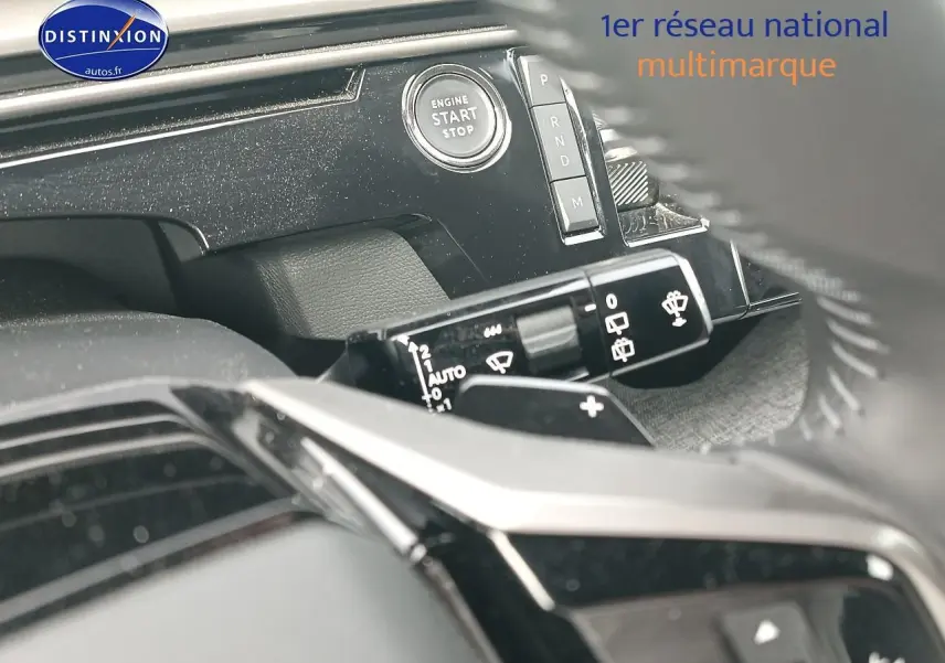 Détail intérieur du tableau de bord noir du Peugeot 5008 Hybrid 145 allure, avec bouton start/stop et commandes au volant.
