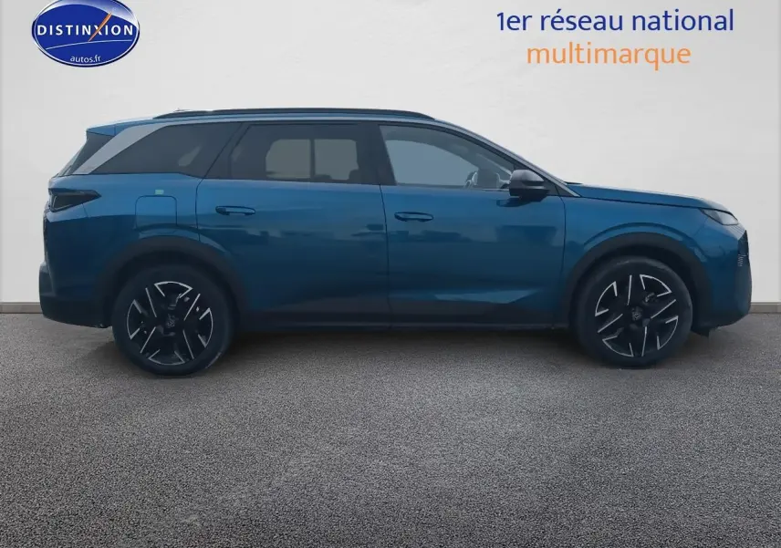 Profil latéral droit d’un Peugeot 5008 Hybrid 145 allure e-dcs6 bleu avec jantes alu et vitres surteintées.