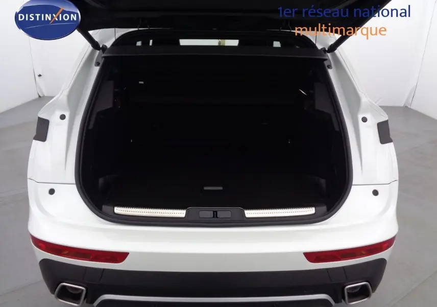 Vue arrière du coffre ouvert d'un DS7 Crossback E-TENSE blanc nacré, soulignant l'espace de chargement vide.