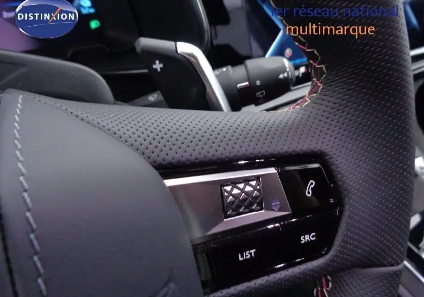 Gros plan sur le volant en cuir noir perforé du DS7 Crossback E-TENSE 300CH, avec commandes intégrées visibles.