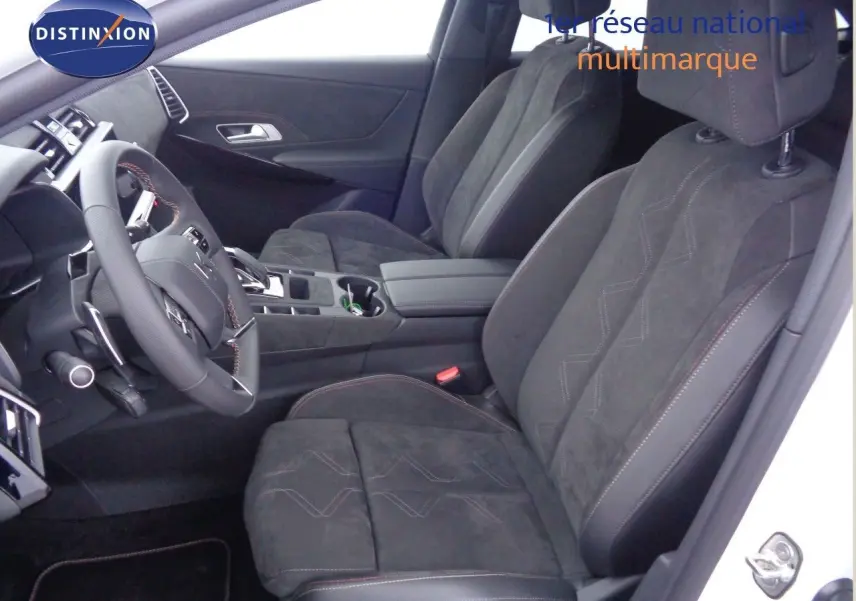 Vue intérieure côté conducteur du DS7 Crossback E-TENSE 300CH en blanc nacré, sièges en cuir noir avec surpiqûres rouges.