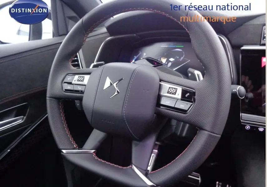 Volant en cuir perforé avec surpiqûres rouges du DS7 Crossback E-TENSE 300CH 4X4, vue rapprochée de l'intérieur conducteur.