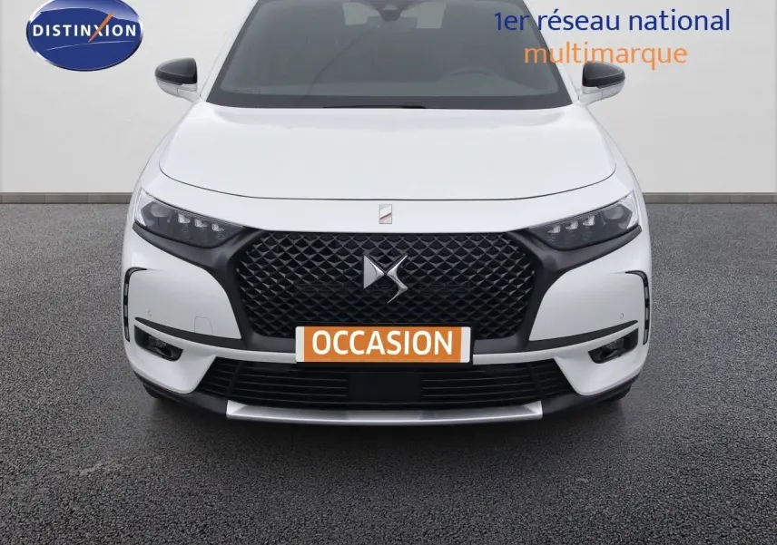 Vue frontale d'un DS7 Crossback E-TENSE blanc nacré avec calandre noire et phares LED distinctifs.