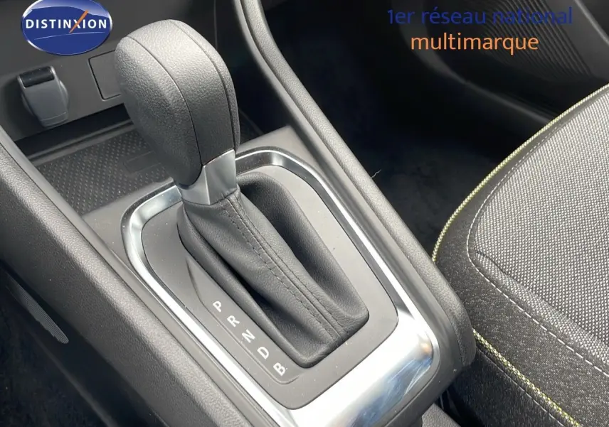 Le levier de vitesse automatique en cuir noir du Renault Captur 2025, avec couture jaune visible sur la sellerie tissu.