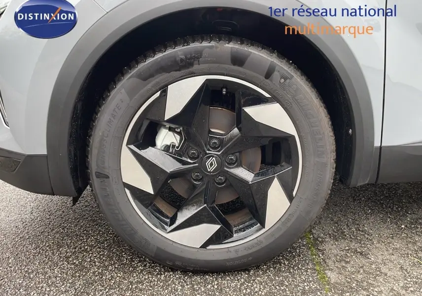 Gros plan sur la roue avant gauche du Renault Captur gris Rafale Métal avec jante noire et argentée au design géométrique.