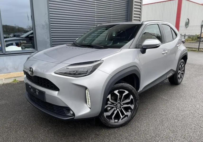 Toyota Yaris Cross gris clair vue 3/4 avant droit, avec phares LED et jantes alliage distinctives.