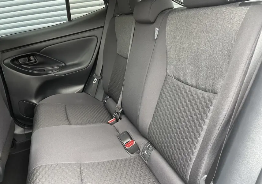 Vue intérieure côté gauche des sièges arrière gris foncé avec ceintures et texture en relief de la Toyota Yaris Cross 2026.