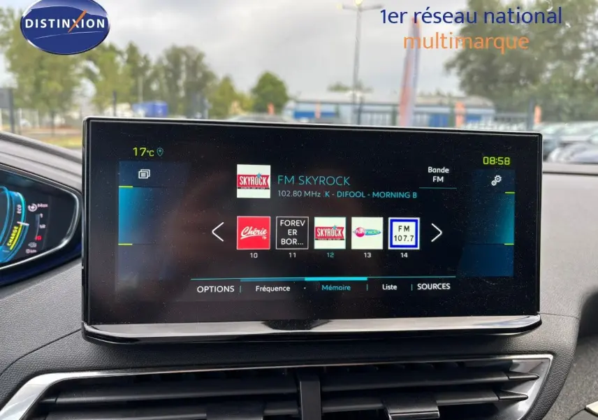 Écran tactile central du Peugeot 3008 hybride 2022 affichant les stations radio FM avec tableau de bord partiel visible.