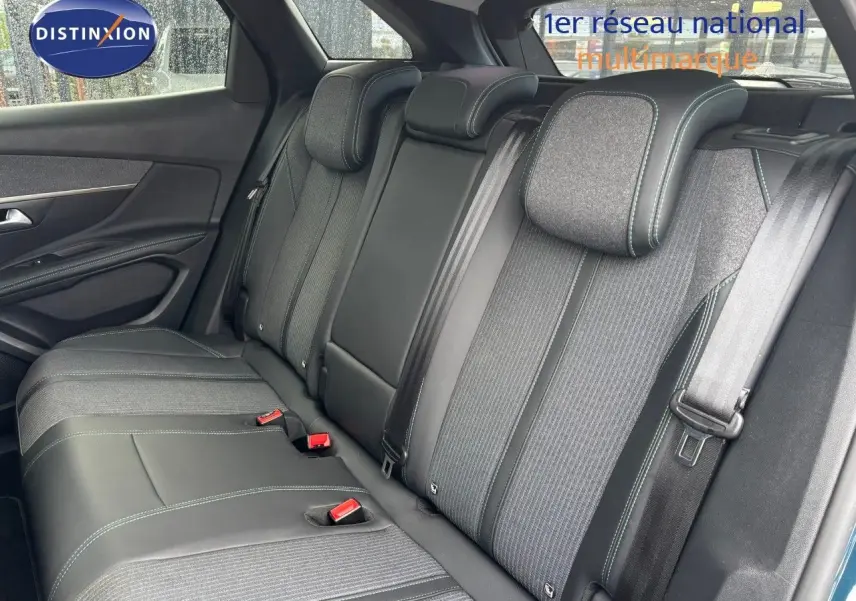 Vue intérieure de la banquette arrière du Peugeot 3008 hybride bleu Celebes avec sièges bi-matière et ceintures visibles.