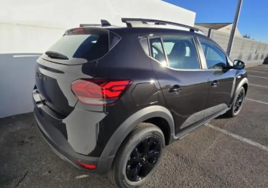 Vue 3/4 arrière droite d'une Dacia Sandero Stepway 2025 noir nacré avec jantes noires et barres de toit