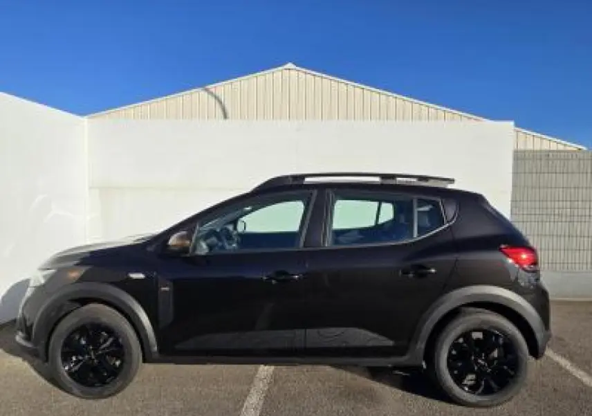 Profil côté gauche de la Dacia Sandero Stepway 2025 noir nacré avec jantes aluminium noires et barres de toit
