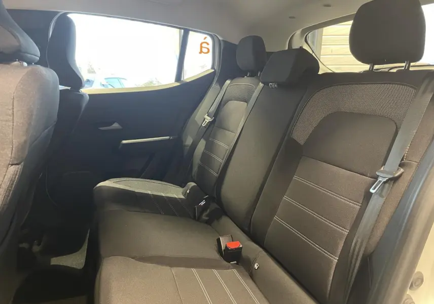 Vue intérieure côté droit sur la banquette arrière noire du Dacia Sandero Stepway 2025 avec appuie-têtes et ceintures visibles.