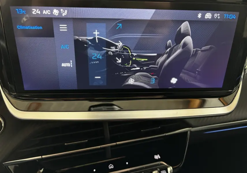 Écran tactile central affichant la climatisation et la vue intérieure des sièges avant et arrière du Peugeot 208 Hybrid gris clair.