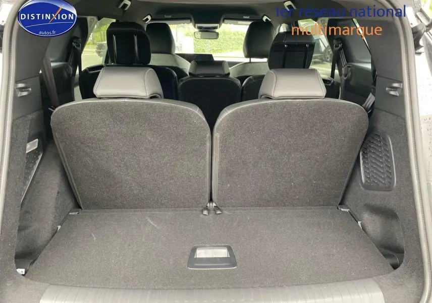 Vue du coffre arrière ouvert du Peugeot 5008 gris titane, montrant les sièges rang 3 relevés et l'intérieur spacieux.
