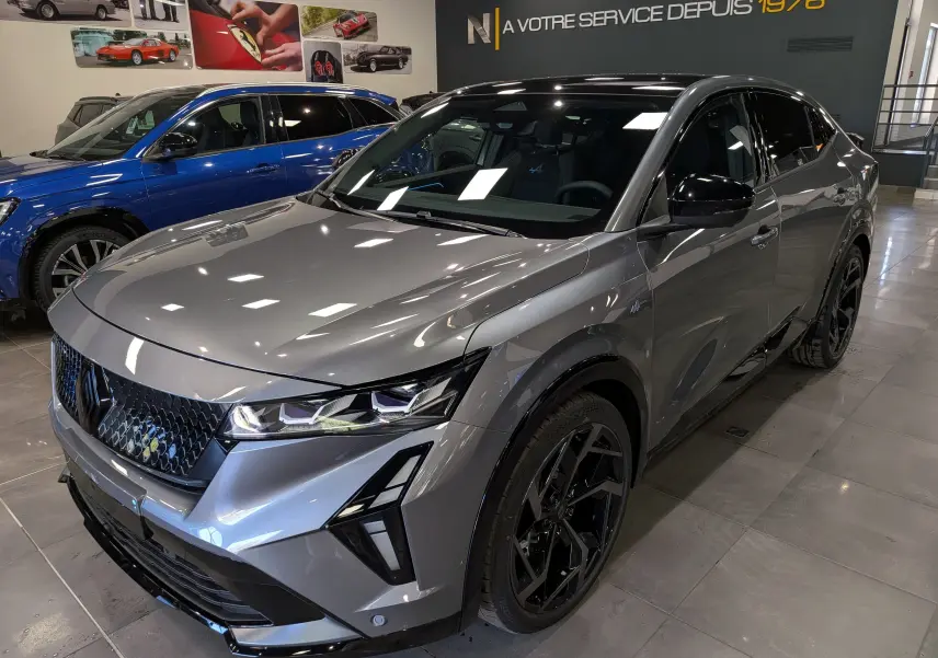Renault Rafale gris schiste en 3/4 avant droit, avec jantes noires et détails noirs brillants, en showroom intérieur.