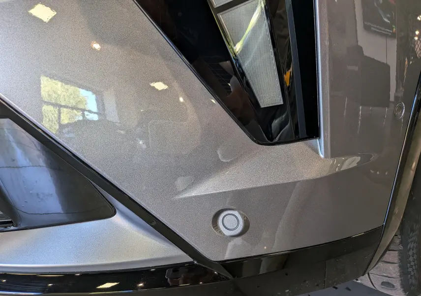 Détail du pare-chocs avant gris schiste de la Renault Rafale 2026 avec capteur de stationnement et éclairage LED.