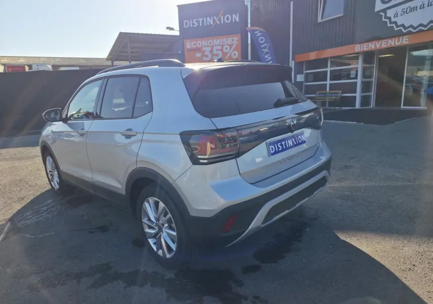 Volkswagen T-Cross gris métallisé vue 3/4 arrière droit, avec jantes alliage 17 pouces et feux arrière LED teintés.