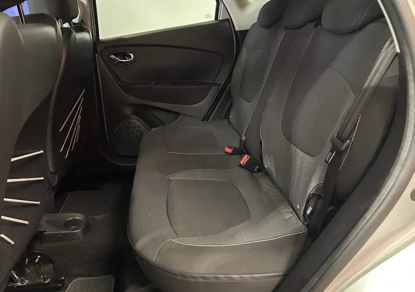Vue intérieure du siège arrière côté droit du Renault Captur gris 2015 avec tissu noir et ceintures visibles.