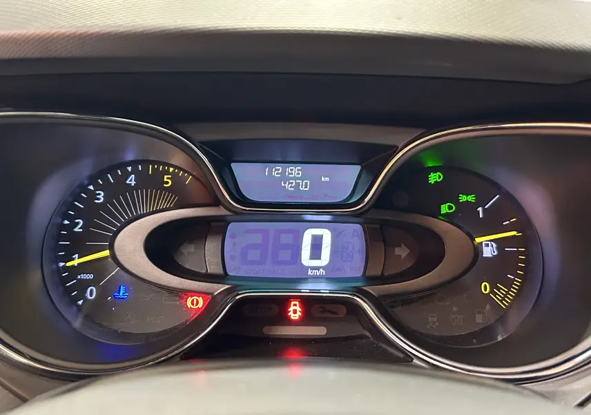 Tableau de bord du Renault Captur gris 2015 montrant le compteur digital à 0 km/h et les voyants allumés.
