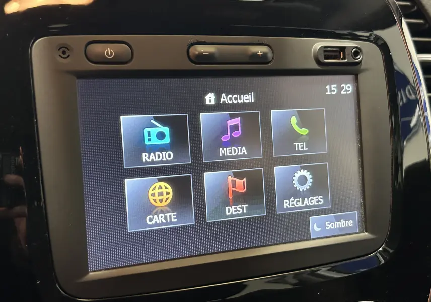 Écran tactile central du Renault Captur 2015 affichant le menu principal avec options radio, média, téléphone, carte, destination et réglages.