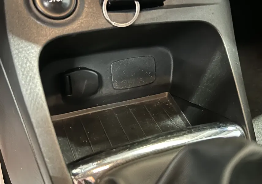 Gros plan sur la console centrale noire du Renault Captur 2015 avec bouton start/stop et espace de rangement.