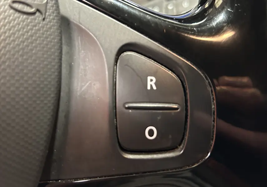 Gros plan sur les boutons R et O noirs sur la partie gauche du volant du Renault Captur gris 2015.